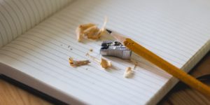 a pencil, a sharpener and a notebook